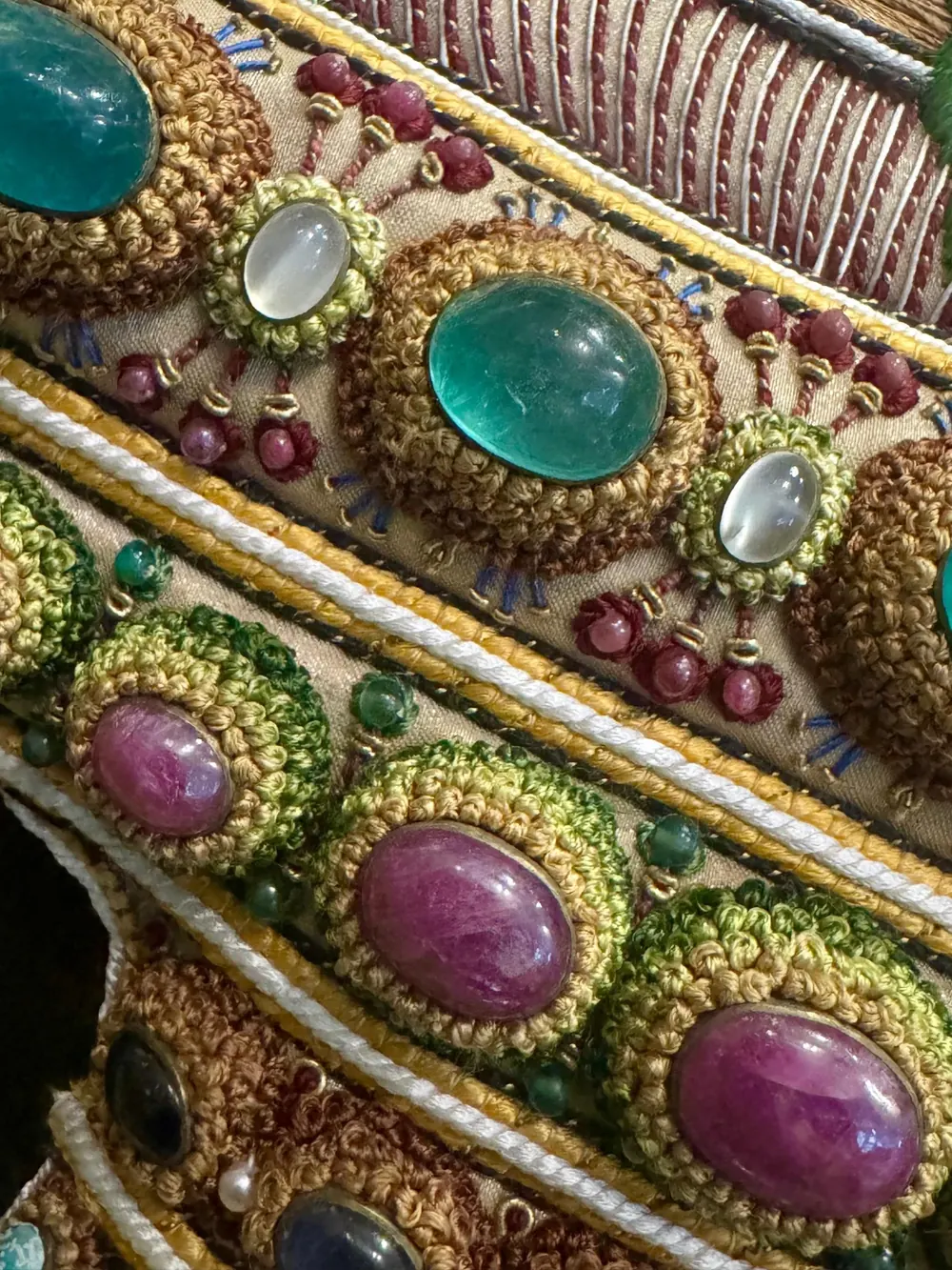 A row of embroidered stone settings